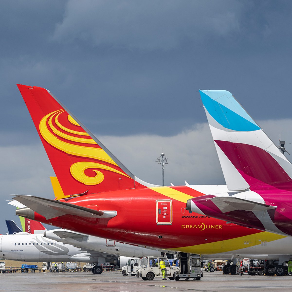 Drei große Flugzeuge am Terminal 1 des Flughafens BER, jeweils nur die hintere Rumpfhälfte mit Leitwerk sichtbar