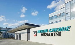 Man sieht das Eingangstor und einen Teil vom Hauptgebäude von Berlin-Chemie, einem Berliner Pharma-Unternehmen, Das Logo des Unternehmens ist am Eingang angebracht , in türkiser Schrift