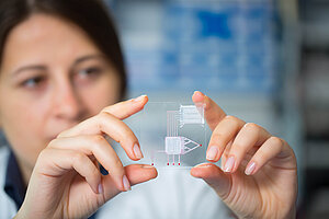 Wissenschaftlerin mit Chip in der Hand