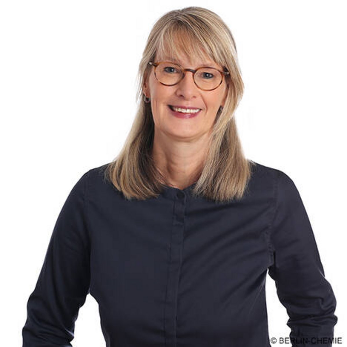 Portrait von Christiane von Eltz, Vorständin bei Berlin-Chemie. Sie ist blond, trägt eine Brille und eine schwarze Bluse und lächelt freundlich.