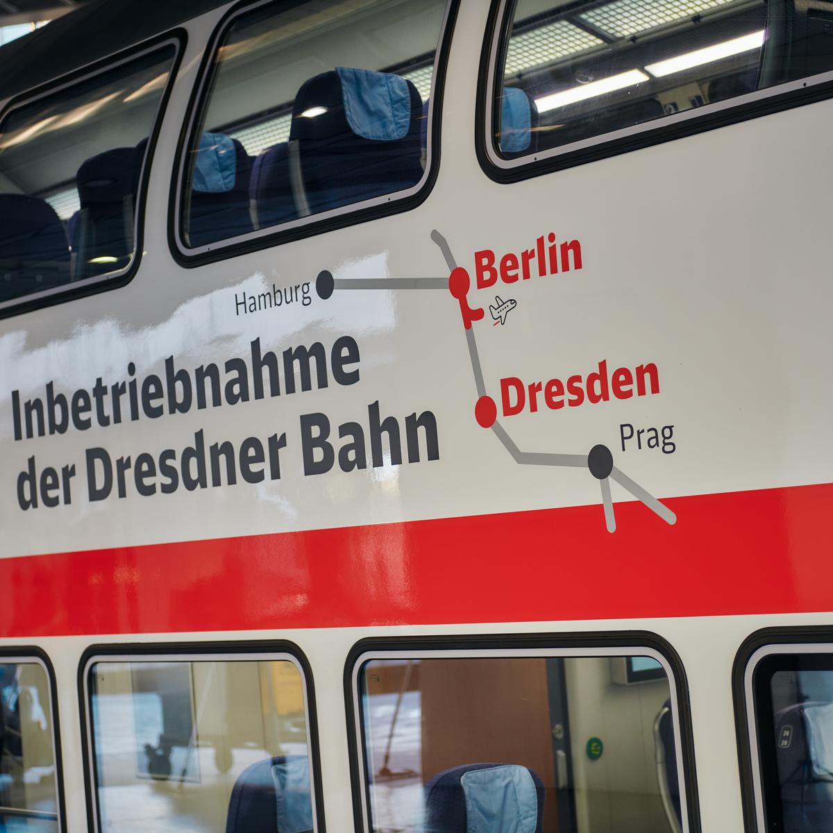 Bild der Bahn mit dem Branding der Strecke Dresden - BER - Berlin