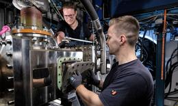 Zwei Mitarbeiter arbeiten am Hochdruckbrennerprüfstand