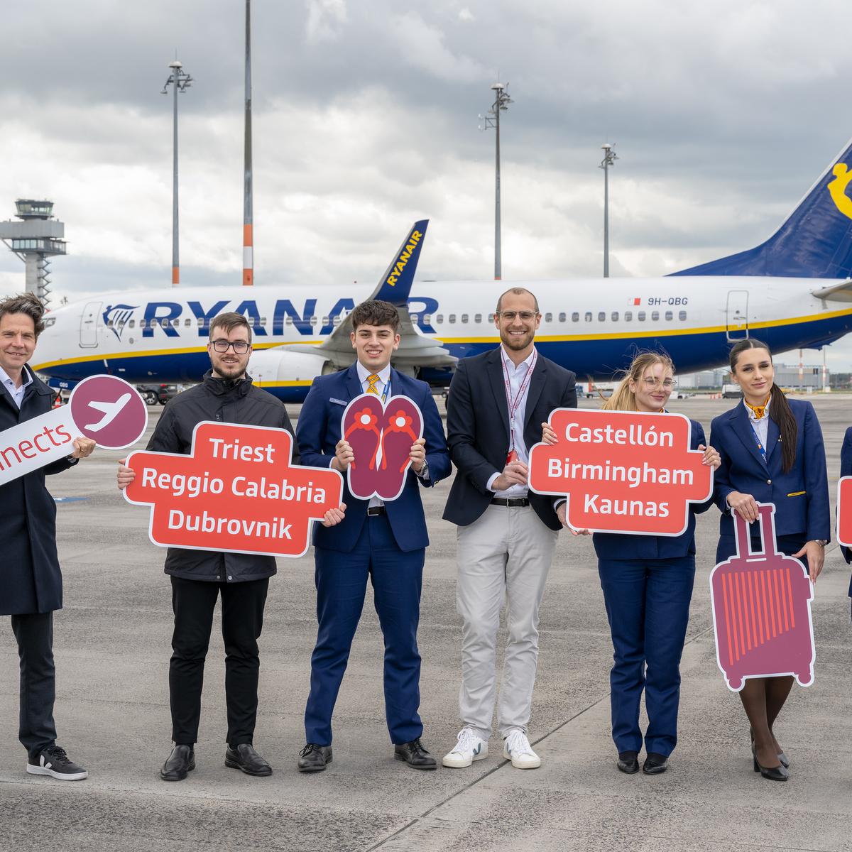 Crew auf dem Rollfeld zu Ryanair baut ihr Flugangebot ab BER aus mit Thomas Kohr, Leiter Corporate ＆ Business Development, Flughafen Berlin Brandenburg GmbH (1.v.l.) und Johannes Mohrmann, Senior Manager Business Development Aviation, Flughafen Berlin Brandenburg GmbH (Mitte) inmitten von Ryanair-Crew.