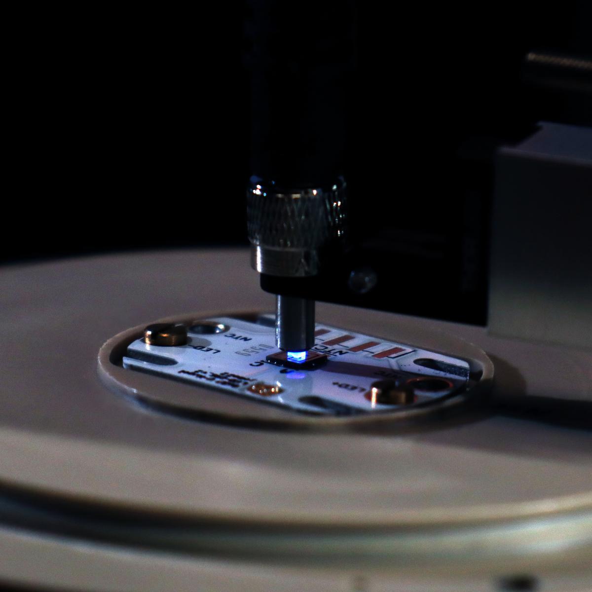 Laboraufbau mit Fern-UVC-LED-Chip bestehend aus Zehntausenden 235 nm Mikro-LEDs, die in eine Glasfaser emittieren.
