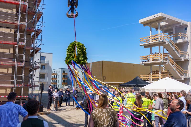 Richtkranzfest von Greenfields in Berlin - Richtkranz wird gehoben; Am Rednerpult (v.l.) Martin Hikel, Bezirksbürgermeister Neukölln, Winfried Hammann, Vorstand der Bürgerstadt AG, Jörg Finkbeiner, Geschäftsführer Partner und Partner Architektur, Helmut Spiehs, Geschäftsführer b_solution GmbH und Christian Gaebler, Senator für Stadtentwicklung, Bauen und Wohnen