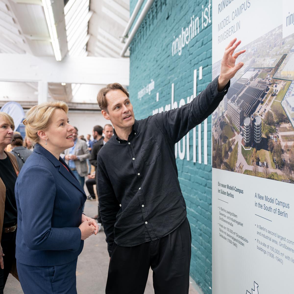 An einem Wand mit der Visualisierung des Pop-Up des Berliner Innovationszentrums Handwerk stehen Carola Zarth, Präsidentin der Handwerkskammer Berlin, Franziska Giffey, Senatorin für Wirtschaft, Energie und Betriebe, Berlin und Matthias Menger, Geschäftsführer ringberlin/KOIMO Development
