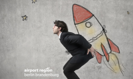 Bild zeigt business man  mit einer gemalten rakete auf dem Rücken. Es sieht aus als würde er starten. Das Bild ist ein Sinnbild für die Gründung eines Unternehmen und das Durchstarten.