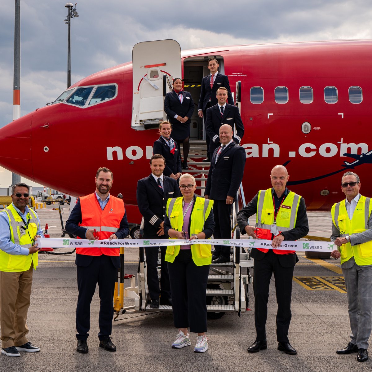 Pressebild zu „Ready for Green“ am Flughafen Berlin-Brandenburg auf dem Rollfeld mit verschiedenen Personen vor einem Flugzeug