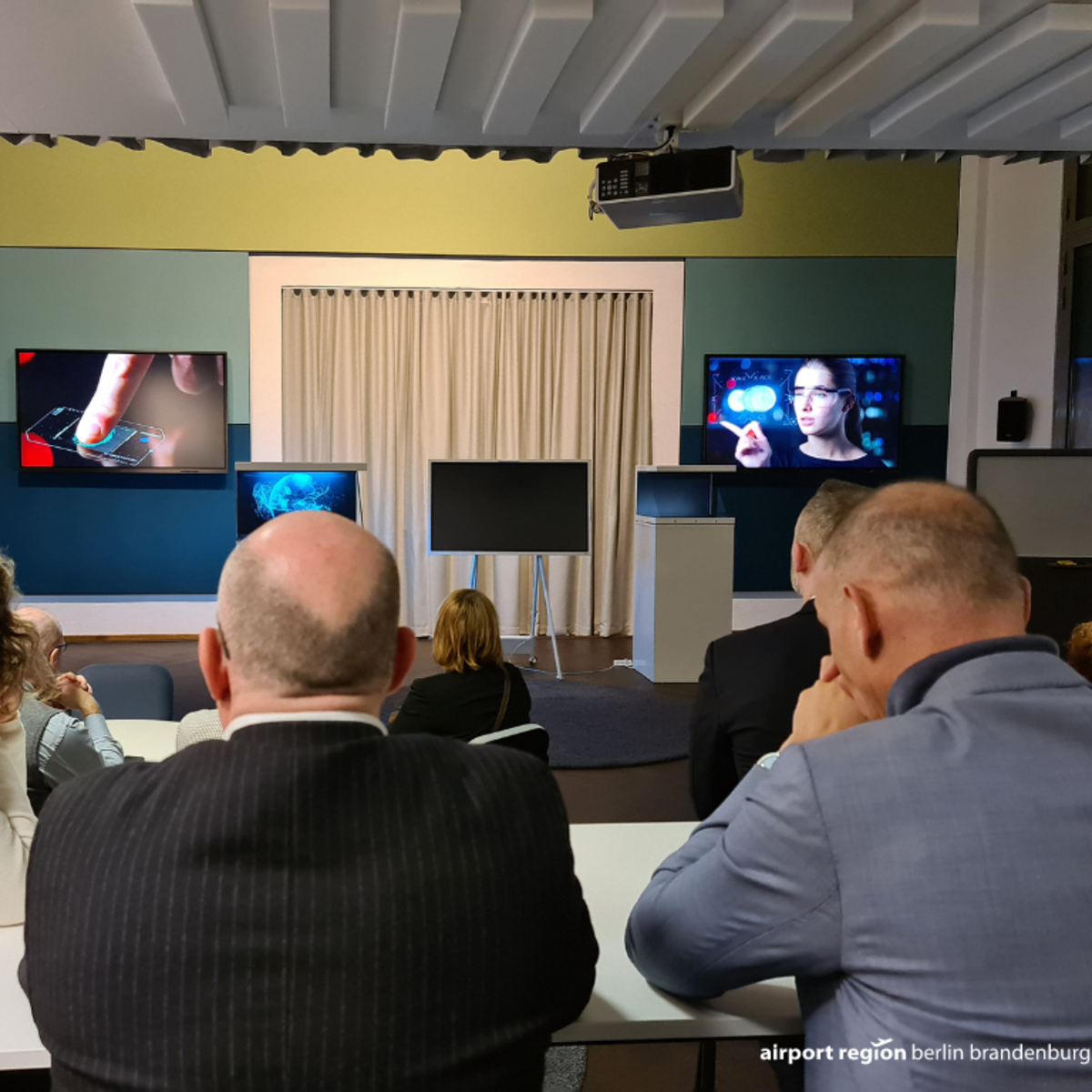 Vorführung im 5G-Showroom der WISTA Adlershof, Gäste schauen und hören gespannt zu.